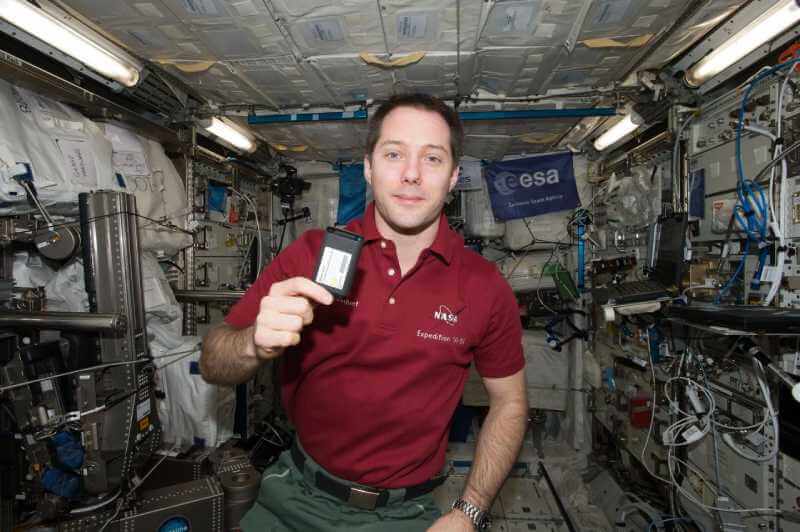 Astronaut holding a Crew Active Dosimeter