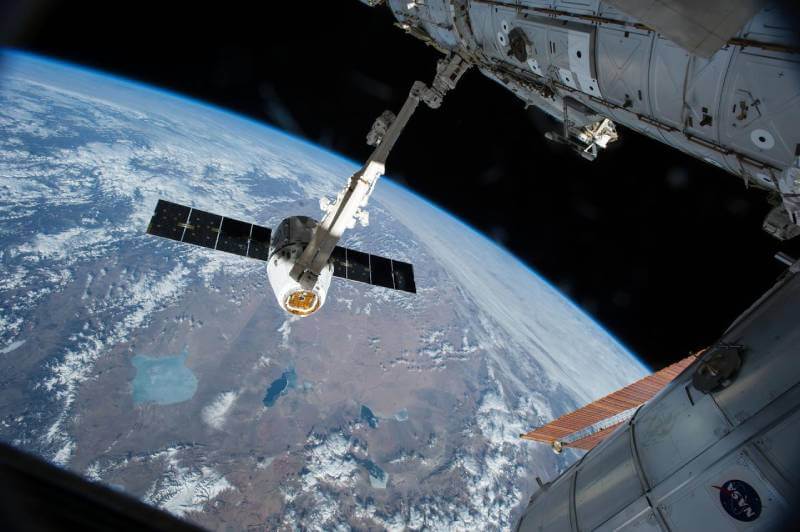 The Canadarm 2 reaches out to grapple the SpaceX Dragon cargo spacecraft