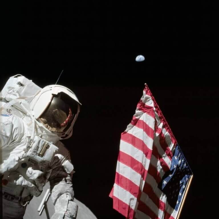 Astronaut with flag on the moon with Earth in the background